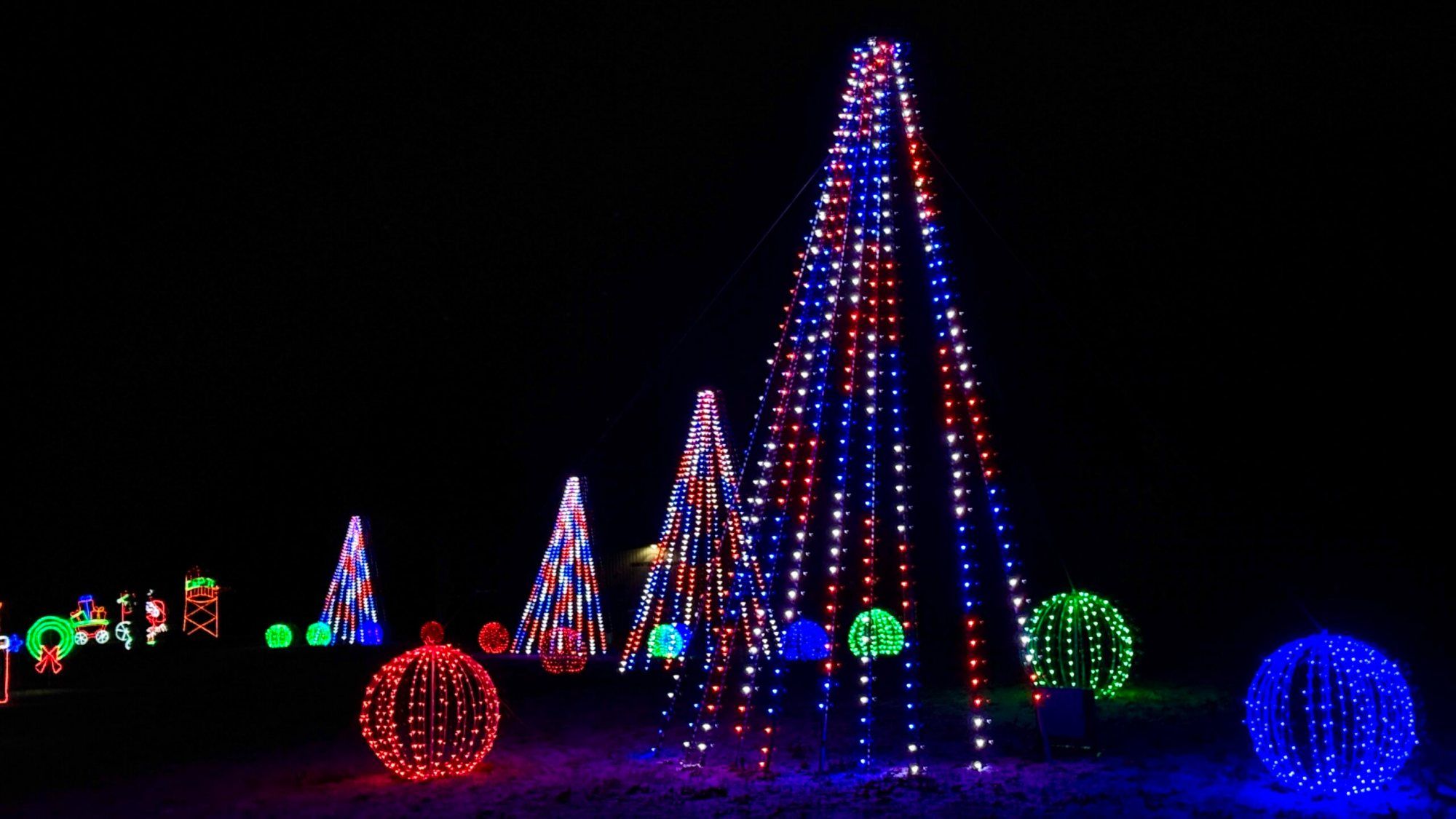 Glowing Christmas tree and ornament globe displays along the route