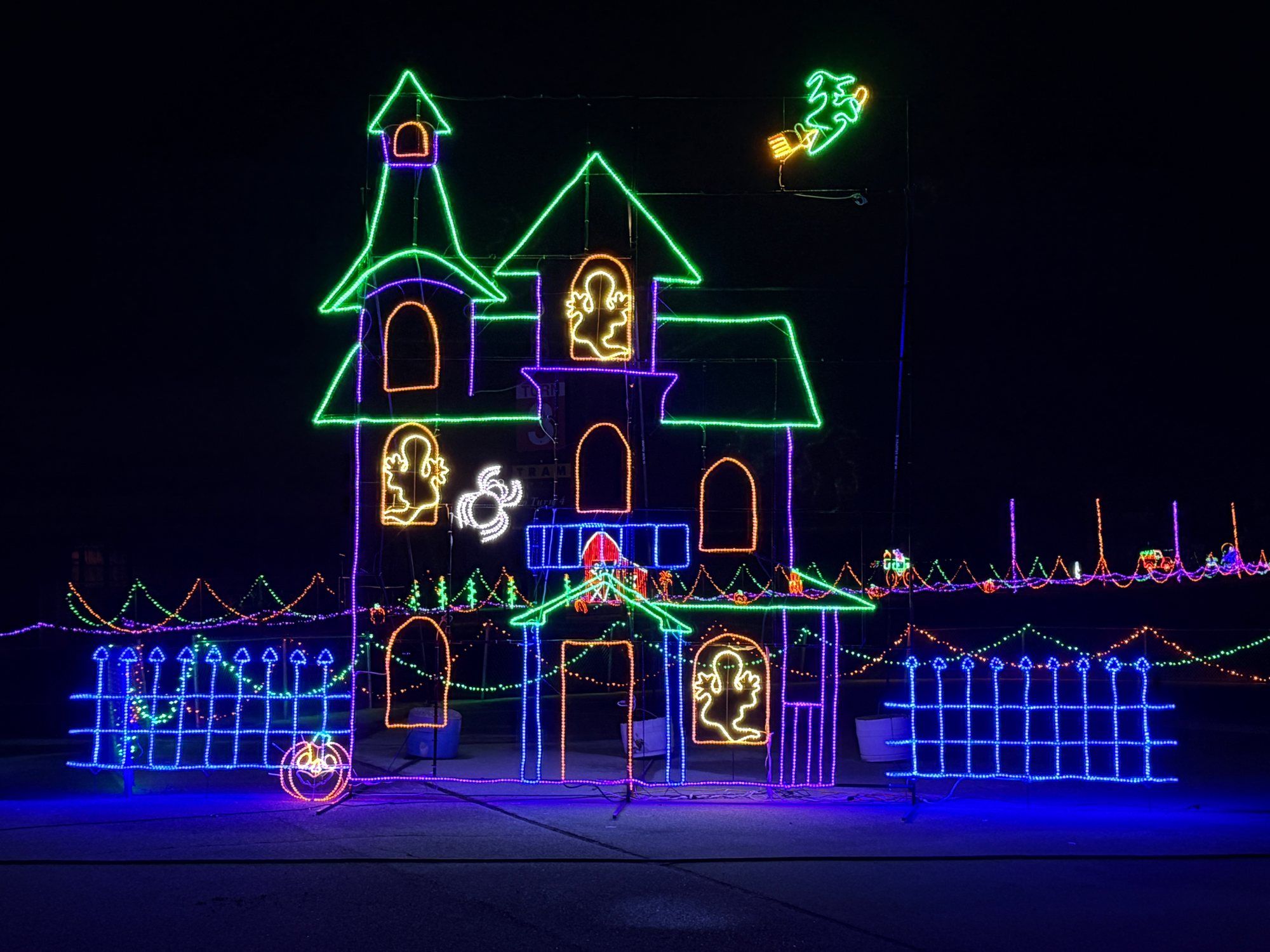 Haunted house light display glowing against the night sky