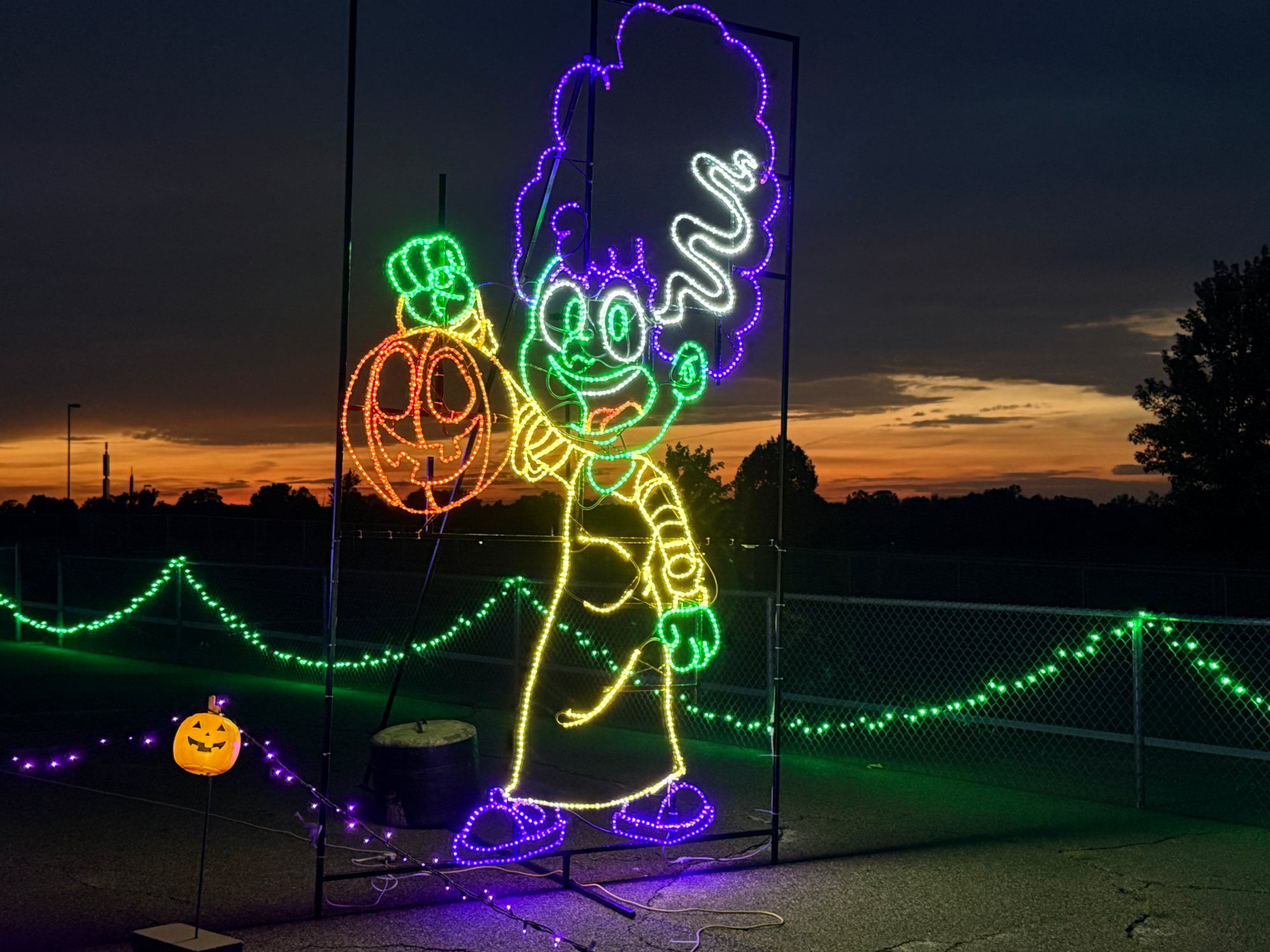Witch silhouette light display against the sunset sky